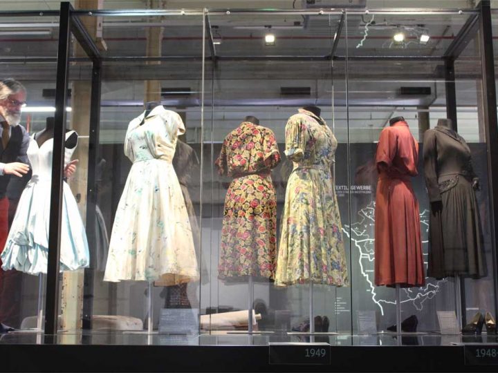 Nach der Reinigung der großen Modevitrine bringt Kurator Martin Schmidt die historischen Kleidungstücke wieder an ihren Platz auf dem "Parcours de la Mode". LWL / Sosatzki